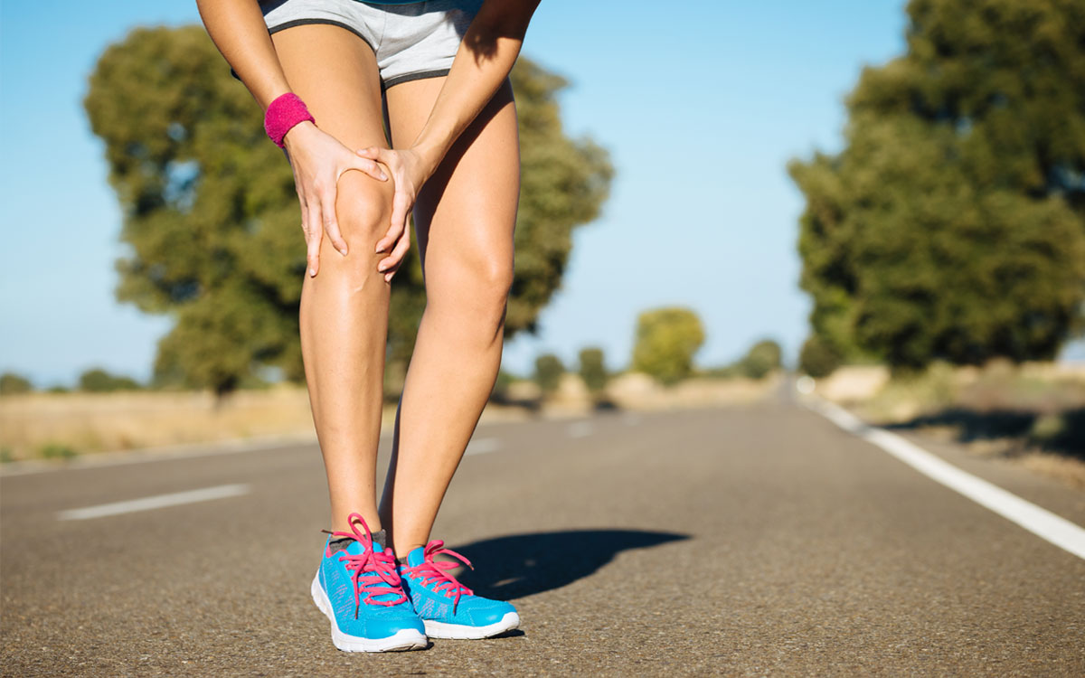 Seseorang berdiri tegak dan melakukan peregangan ringan di luar ruangan